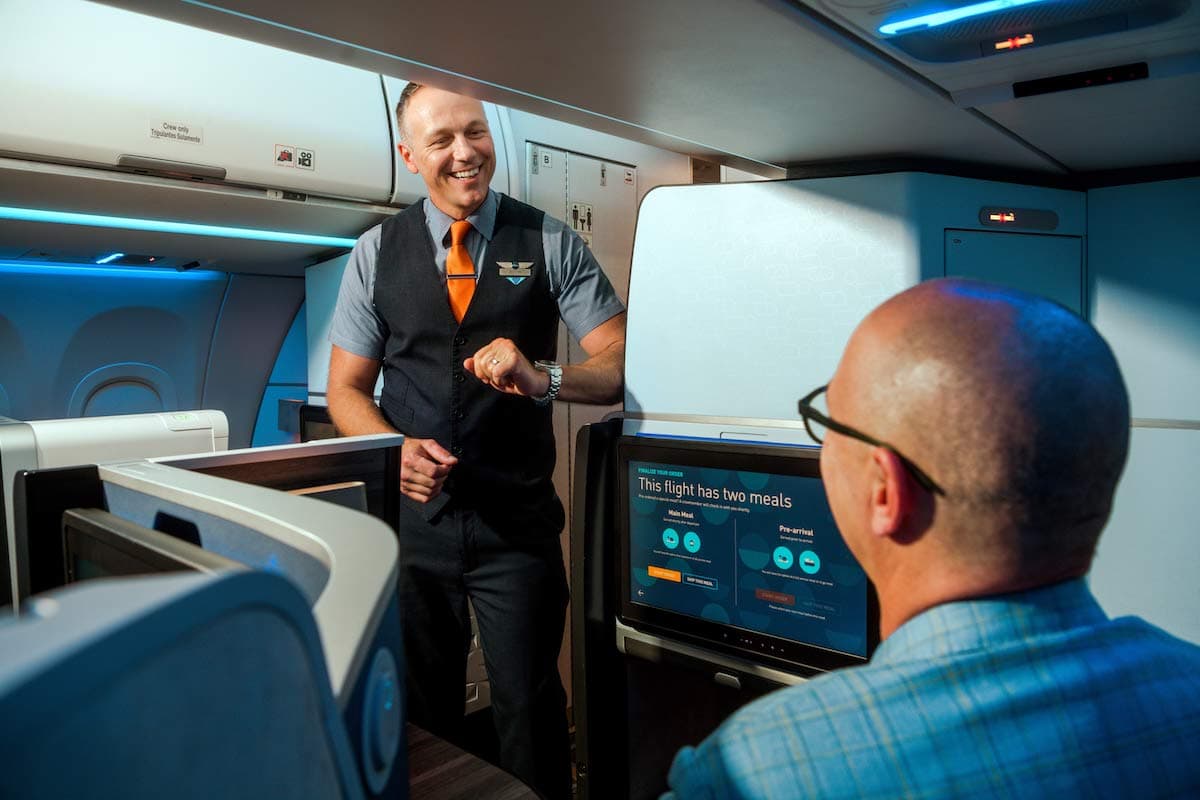 Inflight service on JetBlue: Cabin crew attending to a passenger in a premium cabin.