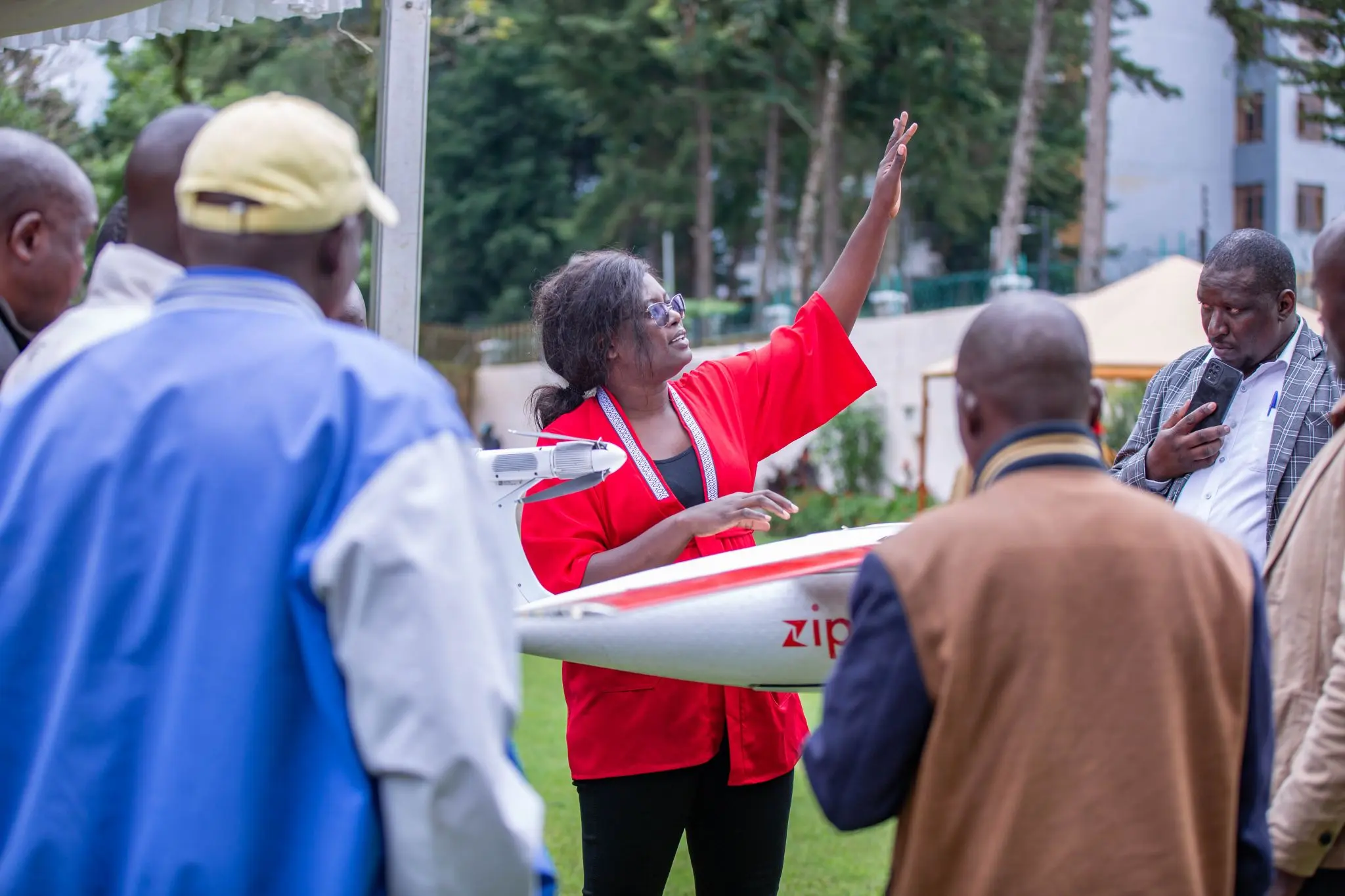 An official, speaking to a group of farmers outdoors at Zipline and Zoetis partnership launch event